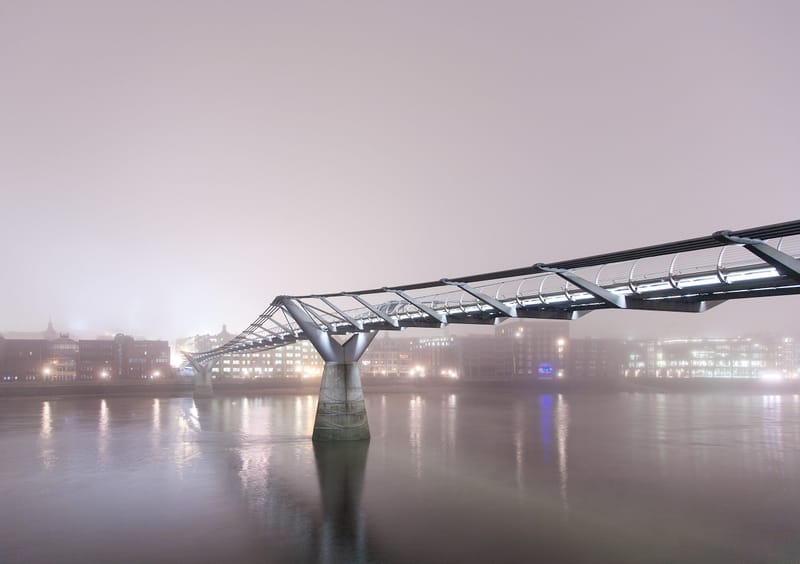 The Millennium Bridge disappearing into fog above a glassy Thames