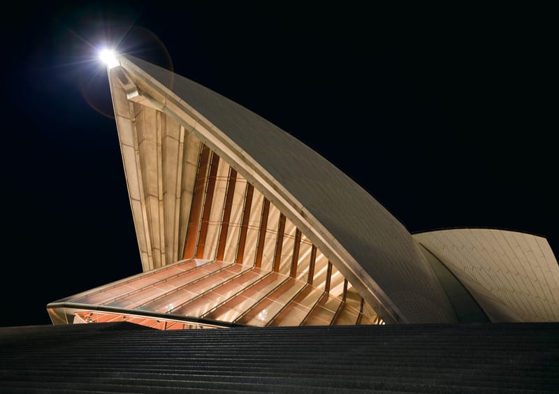 The sails of the Sydney Opera House lit against the night sky