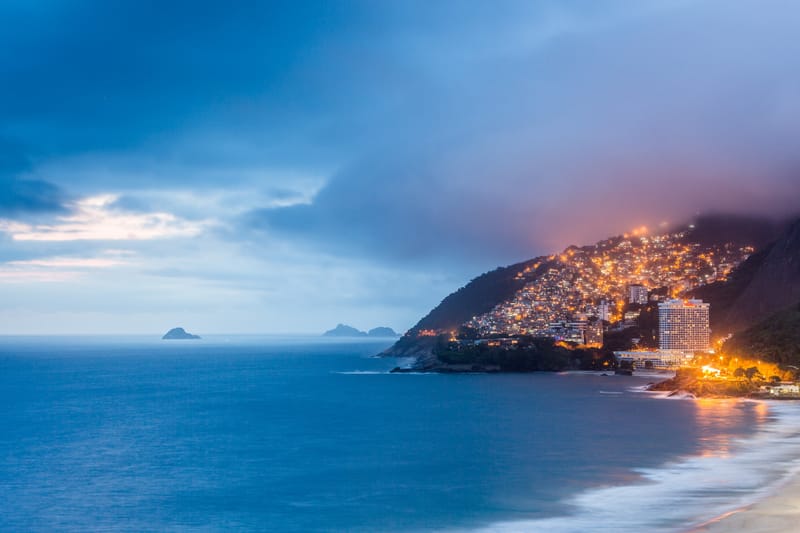 The lights of Vidigal glowing at dusk above a dark sea, Rio de Janeiro