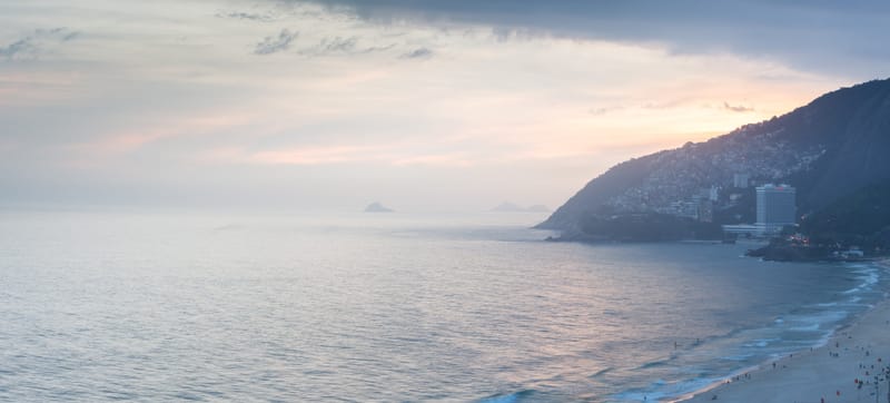 Panorama of the Rio de Janeiro coastline at dusk, the sea fading toward distant headlands