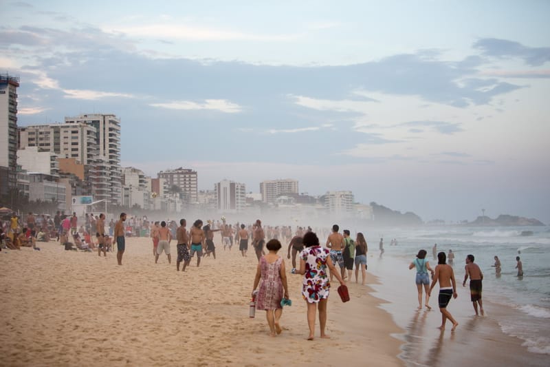 Crowds on Ipanema beach on a hazy afternoon, apartment blocks behind, Rio de Janeiro