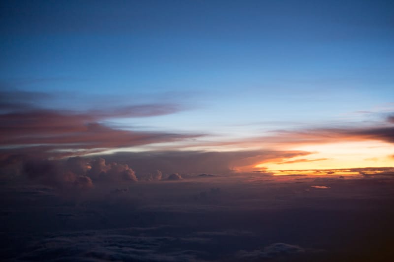 Dusk cloudscape seen from the air, last light along the horizon